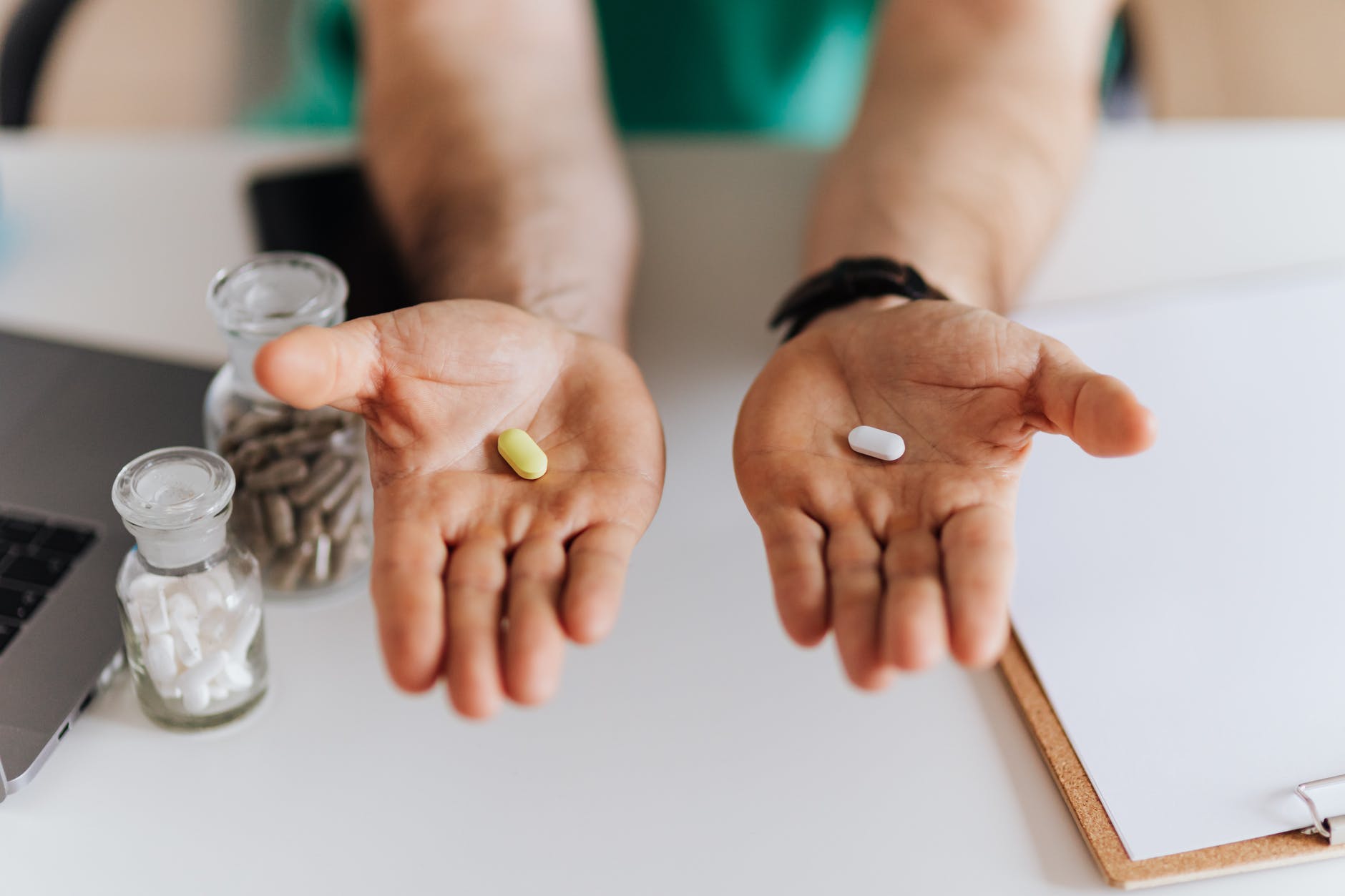 crop doctor showing pills to patient in clinic